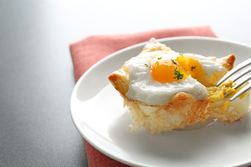 Tasty baked egg in dough with fork on plate