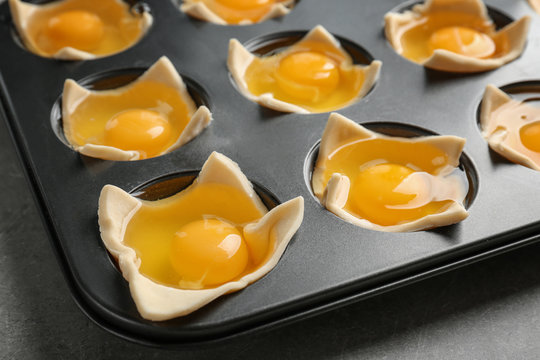 Baking mold with raw eggs in dough, closeup