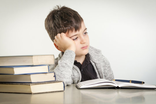 Studio portrait of young boy struggling with his homework - learning difficulties concept