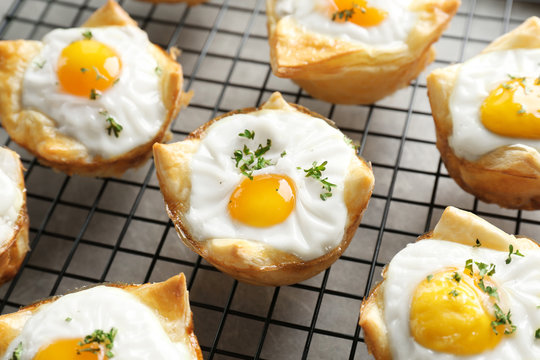 Tasty baked eggs in dough on cooling rack