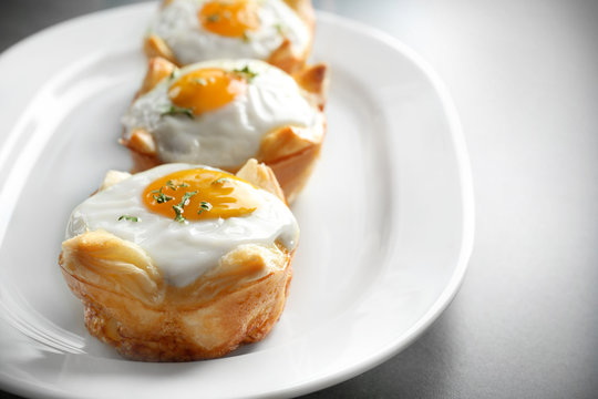 Tasty baked eggs in dough on plate