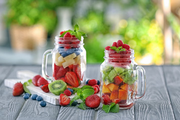Mason jars with fruits and berries on table
