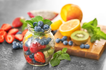 Jar with fruits and berries on table