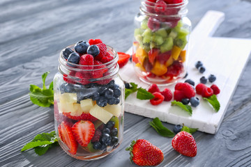 Jars with fruits and berries on table