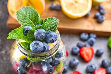 Jar with berries on table, closeup