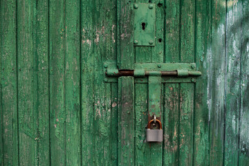 Old green wooden texture background with an old lock. Vertical wood planks
