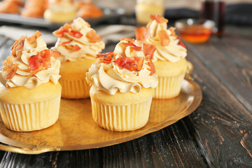 Tasty cupcakes with bacon on metal tray
