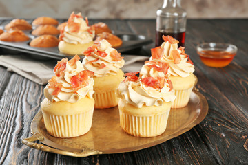 Tasty cupcakes with bacon on metal tray