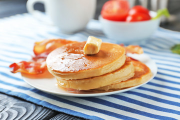 Tasty breakfast with pancakes and bacon on plate