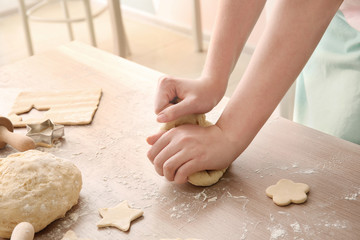 Woman kneading puff pastry at table in kitchen