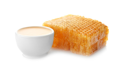 Bowl of honey and comb on white background