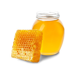 Jar of honey with comb on white background