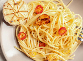 Delicious pasta with garlic and chili pepper on plate, closeup
