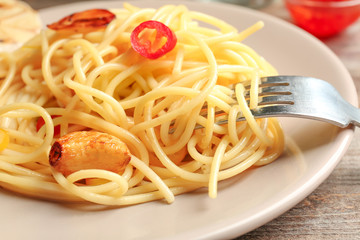 Delicious pasta with garlic and chili pepper on plate, closeup