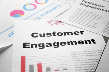 Fototapeta premium Sheet of paper with text CUSTOMER ENGAGEMENT on table