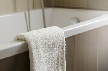 White towel on the bath in bathroom with brown ceramic shallow - obrazy, fototapety, plakaty