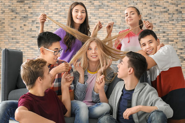 Group of cool teenagers having fun indoors