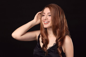 Obraz premium Young woman with caramel hair color on black background