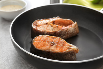 Tasty rainbow trout steaks on frying pan, closeup