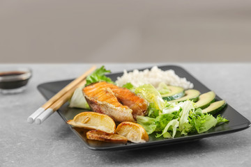 Plate with tasty rainbow trout steak and garnish on table