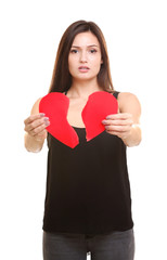 Young woman holding torn paper heart on white background