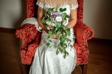 bride with wedding bouquet. Woman sitting in a chair. Beautiful mix white violet peonies and eustoma