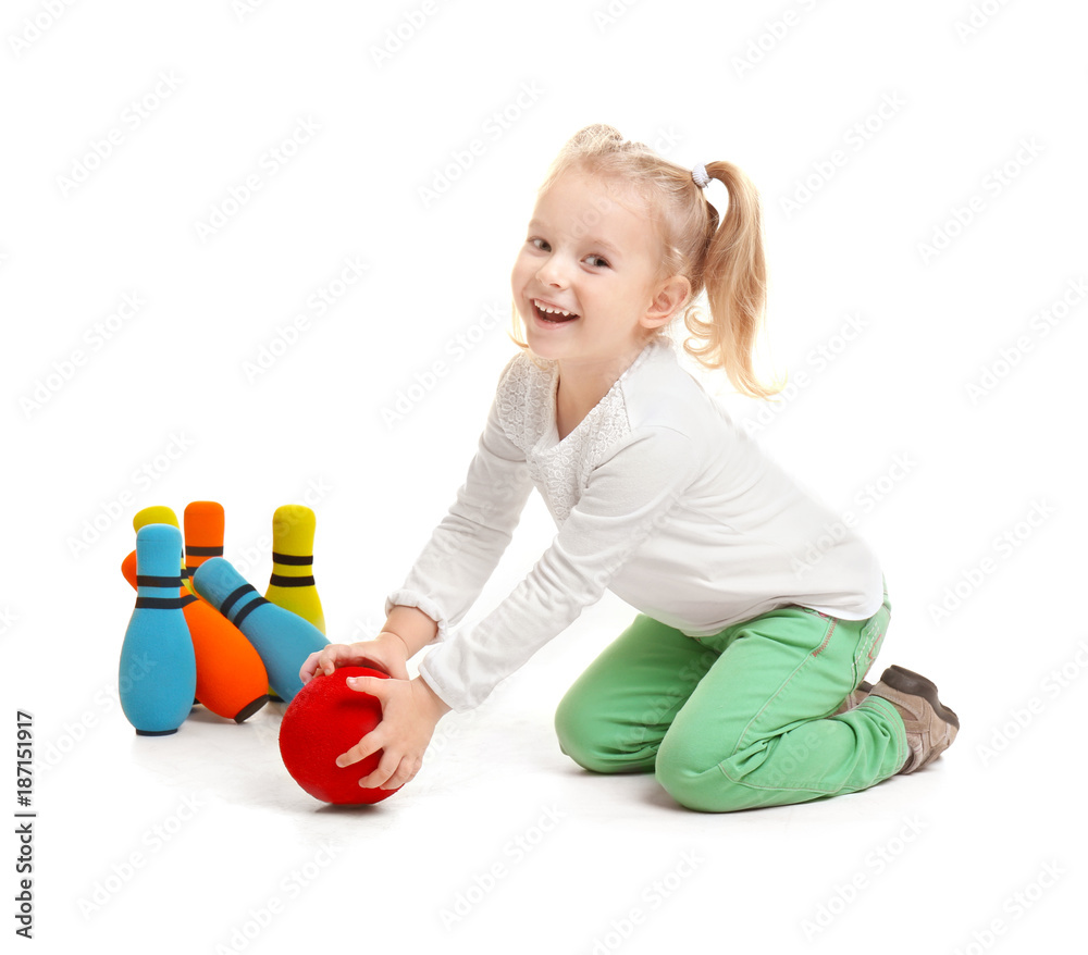 Wall mural cute little girl playing bowling on white background