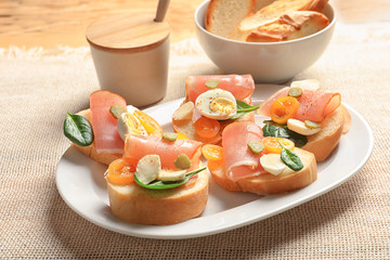 Plate with tasty fresh bruschettas on table