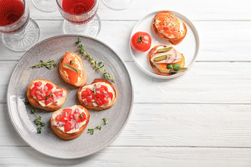 Plate with tasty fresh bruschettas on table