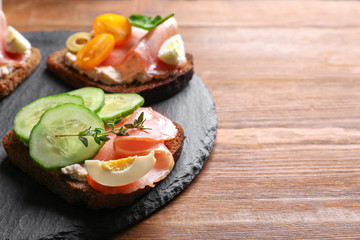 Slate plate with tasty fresh bruschettas on table