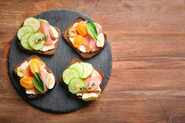 Slate plate with tasty fresh bruschettas on table