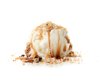 Ice cream ball covered with caramel sauce and crumbled cookies on white background