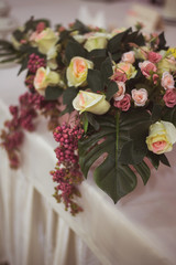 Wedding decor from a bouquet of pink roses and green foliage