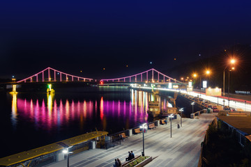 Night landscape. The city of Kiev, Ukraine, Europe. Pedestrian bridge across the Dnieper River with riverfront