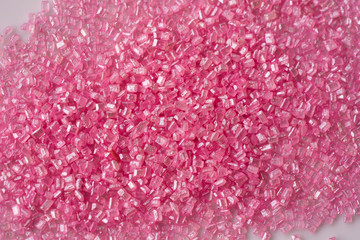 Closeup of a pile of pink sugar crystals (cake decor), from above
