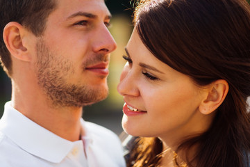 girlfriend with a beautiful makeup stands near her bearded boyfriend