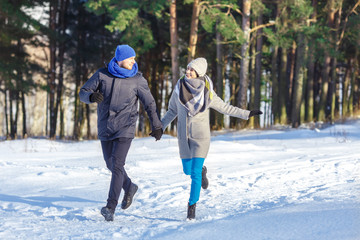 Fototapeta na wymiar Happy Young Couple in Winter Park laughing and having fun. Family Outdoors.