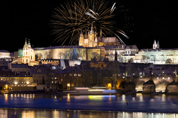 Fireworks above night colorful snowy Prague gothic Castle with Charles Bridge, Czech republic