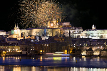 Fireworks above night colorful snowy Prague gothic Castle with Charles Bridge, Czech republic