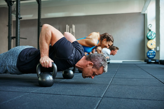 Fit people doing pushups together in a health club class