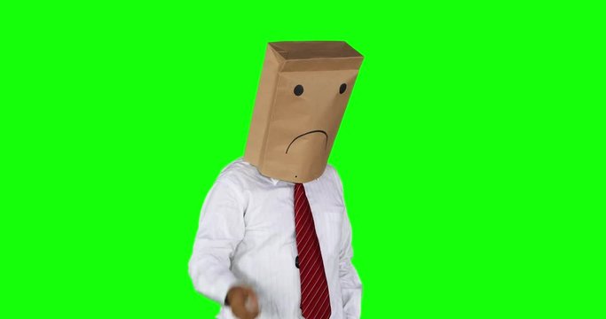 Anonymous businessman with paper bag on his head looks confused, thinking idea while scratching his head. Shot in 4k resolution with green screen background