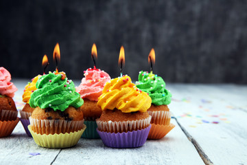 Tasty cupcakes on wooden background. Birthday cupcake in rainbow colors