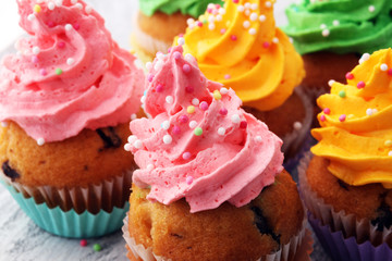 Tasty cupcakes on wooden background. Birthday cupcake in rainbow colors