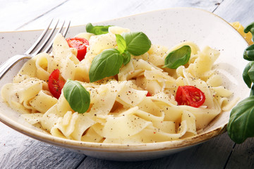 fettucine pasta white cream sauce with tomato and basil in white plate - Italian food style