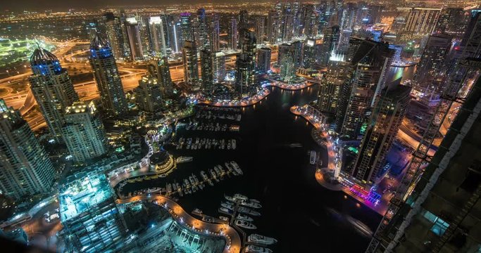DUBAI, UAE – MARCH 2016 : Beautiful Timelapse of Dubai Creek at night with boats, harbor and cityscape in view