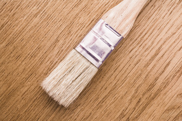 mayal brush with natural nap and wooden handle lies on a wooden oak desk