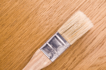 mayal brush with natural nap and wooden handle lies on a wooden oak desk