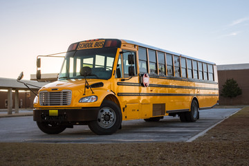 Fototapeta na wymiar American Yellow Black School Bus on School Grounds Transportation Vehicle
