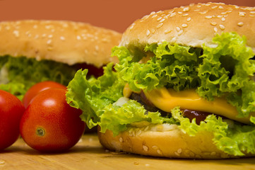 two vegan hamburger on a wooden board, orange background.