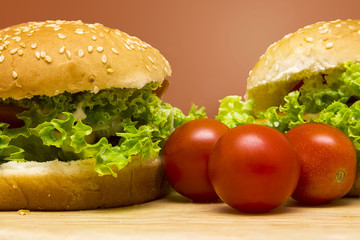 two vegan hamburger on a wooden board, orange background.